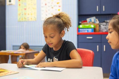 Young girl reading at Girls Inc.