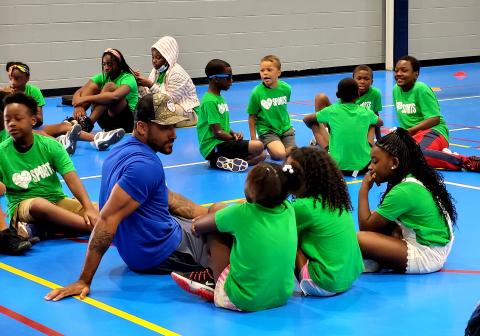 Retired, professional baseball player Ian Desmond sits with students from Newtown Connection program.