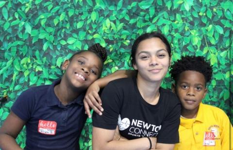 Three students from Newtown Connection stand, smile at camera.