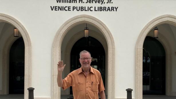 Bill Jervey standing, smiling, waving outside of William H. Jervey, Jr. Venice Public Library