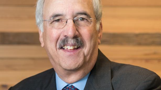 Man in suit smiling at camera.