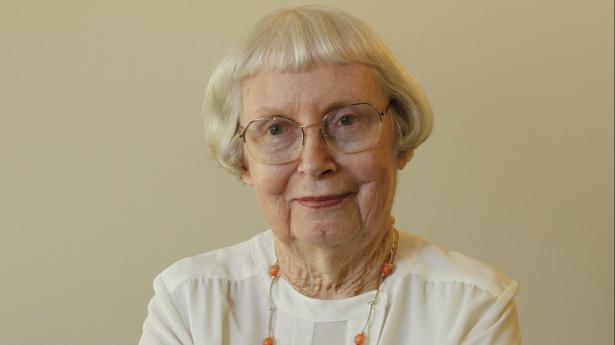 Julia Cousins Laning smiling at camera with arms crossed.