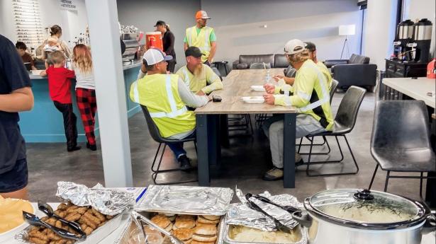 Lineman helping with Hurricane Ian sitting at table eating.