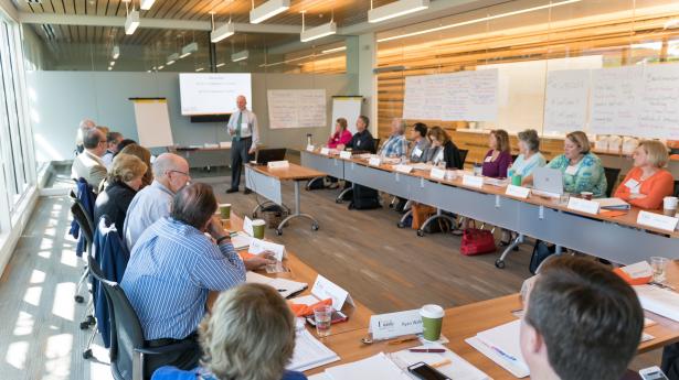 Gulf Coast's Venice Headquarters board room with participants of an I3 workshop sitting and a consultant standing at the front. Tables are centered around each other.