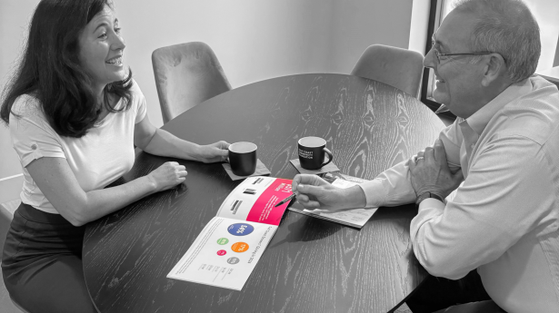 black and white photo of a man and woman smiling at each other across the table