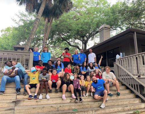 Camp Mariposa campers and staff posing outside on deck for their favorite “silly” group photo.