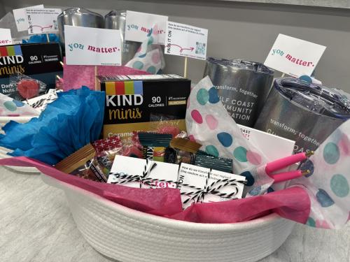 White basket filled with paper flowers, grey large cups, you matter kindness cards.