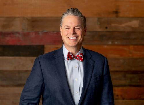 Phillip P. Lanham, Gulf Coast's new president | CEO, smiles with dark wood wall in background.