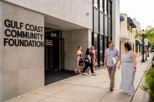 Five people walking in front of Gulf Coast Community Foundation's downtown Sarasota Philanthropy Center.
