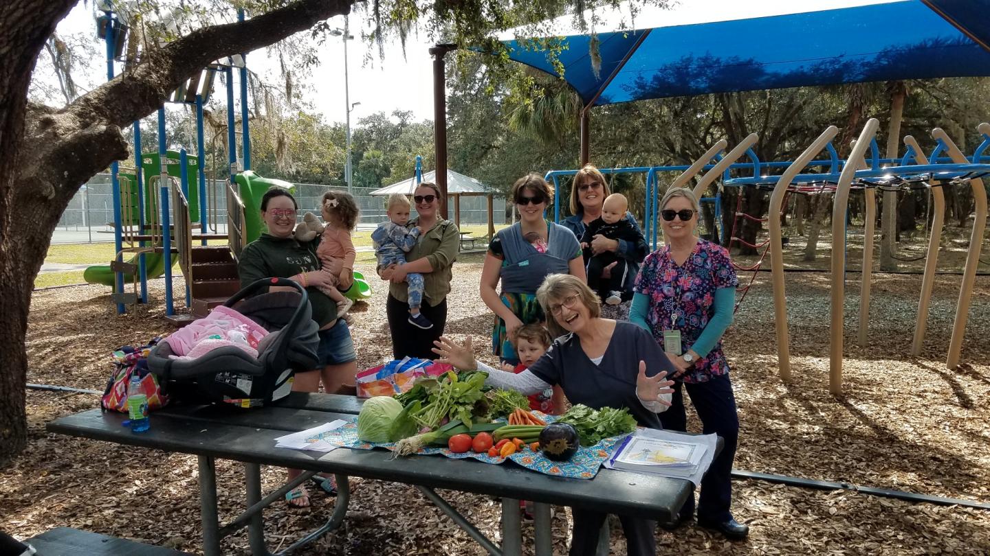 Mothers in the park with their children smiling